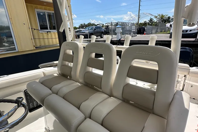  Yacht Photos Pics 2017 Boston Whaler 350 Outrage boat interior with beige seating and steering wheel.