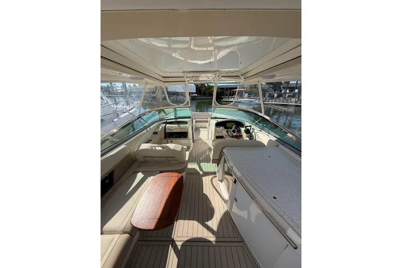  Yacht Photos Pics 2018 Regal 33 OBX boat interior with seating, table, and helm in a marina setting.