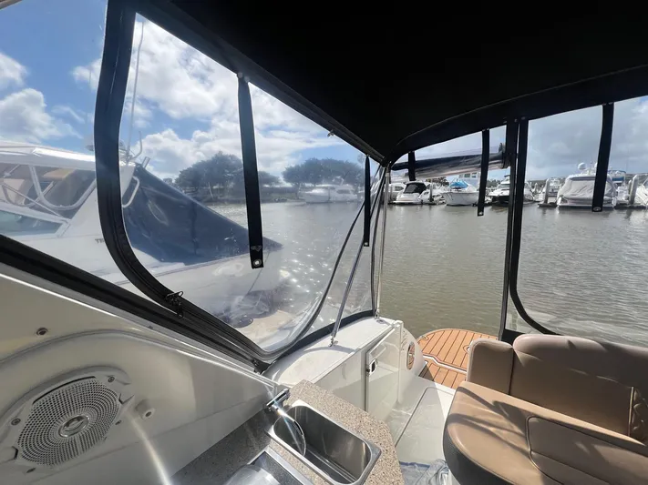  Yacht Photos Pics 2016 Sea Ray 310 Sundancer interior view at marina, featuring seating and watercraft.