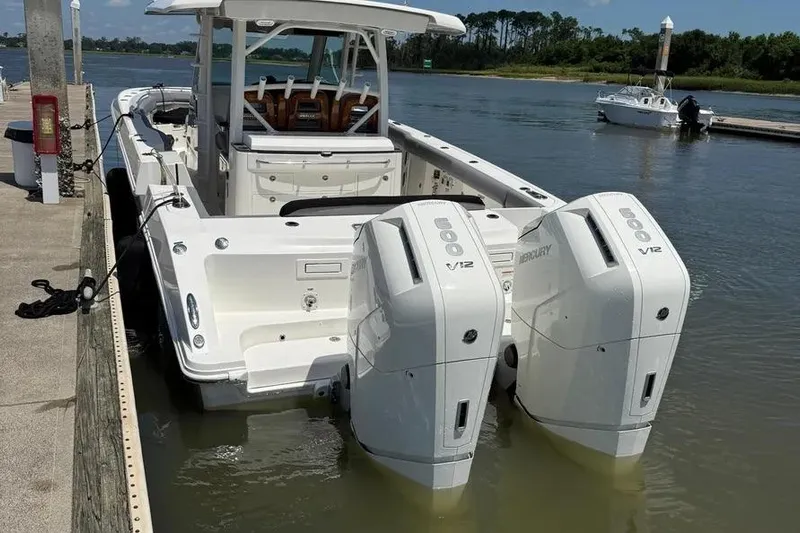  Yacht Photos Pics 2024 Boston Whaler 380 Outrage with dual Mercury V12 engines docked by the water.