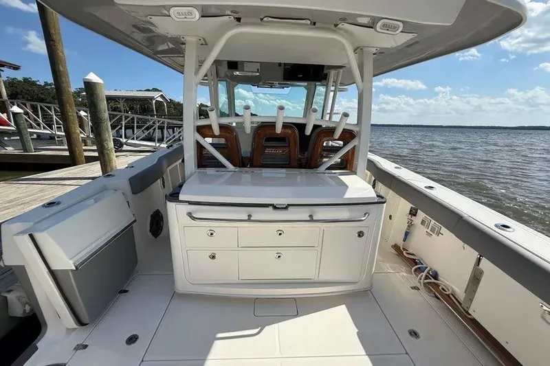  Yacht Photos Pics 2024 Boston Whaler 380 Outrage boat interior with seating and storage, docked by the water.