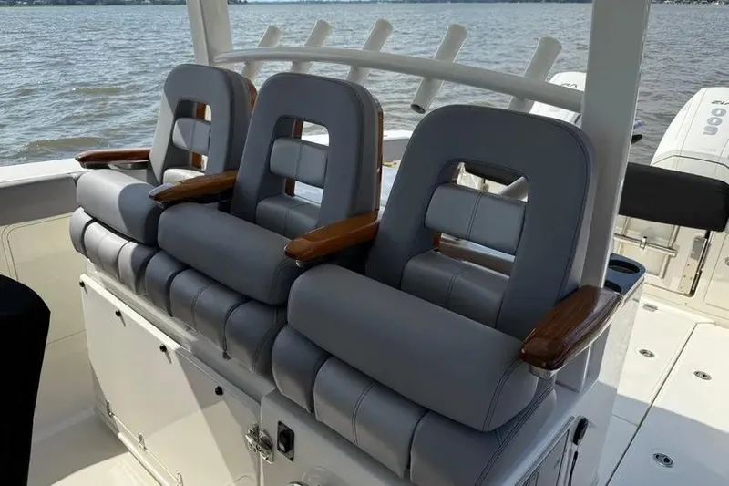  Yacht Photos Pics 2024 Boston Whaler 380 Outrage boat seats with wooden armrests on open water.