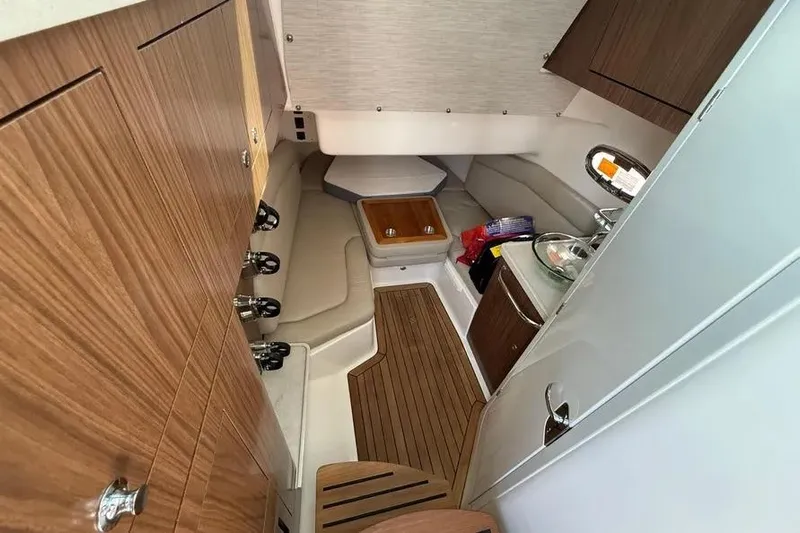  Yacht Photos Pics 2024 Boston Whaler 380 Outrage cabin interior with wood accents and seating area.