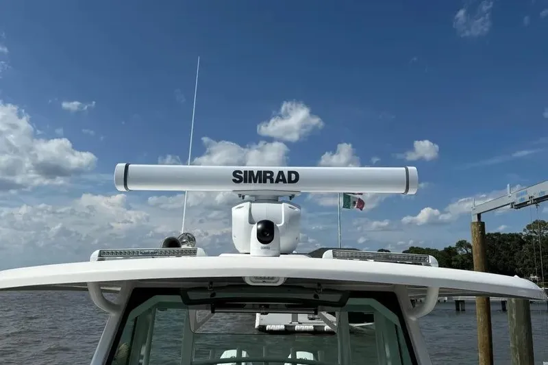  Yacht Photos Pics 2024 Boston Whaler 380 Outrage with Simrad radar, docked under a clear sky.