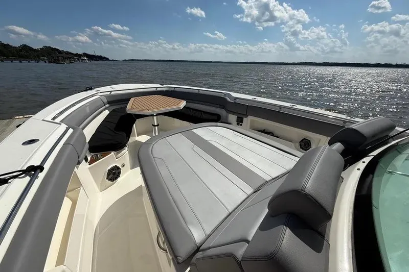  Yacht Photos Pics 2024 Boston Whaler 380 Outrage boat interior with seating and table on a sunny day.