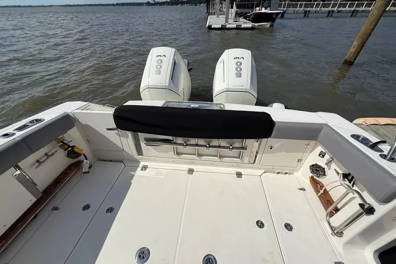 Yacht Photos Pics 2024 Boston Whaler 380 Outrage boat with dual outboard engines docked on a lake.