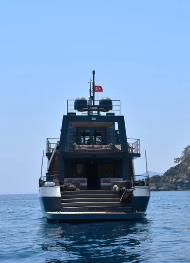 Risk Taker Yacht Photos Pics Tansu Custom Trawler 2006 yacht on calm sea with Turkish flag, rear view.