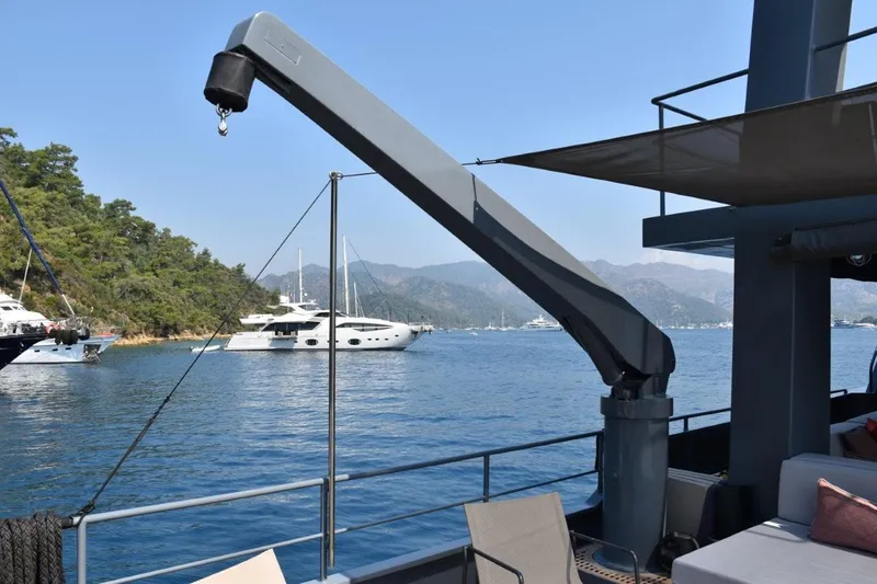 Risk Taker Yacht Photos Pics Tansu Custom Trawler 2006 yacht with crane, scenic coastal view, and anchored boats.
