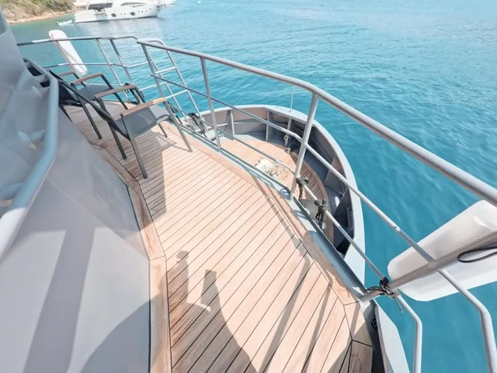 Risk Taker Yacht Photos Pics Tansu Custom Trawler 2006 yacht deck with chairs, overlooking clear blue water.