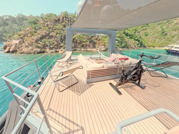 Risk Taker Yacht Photos Pics Luxurious 2006 Tansu Custom Trawler deck with lounge, exercise bike, and scenic ocean view.