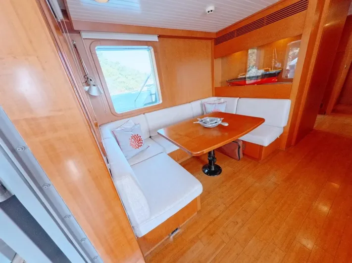 Risk Taker Yacht Photos Pics Luxurious 2006 Tansu Custom Trawler interior with cozy dining area and elegant wood finishes.