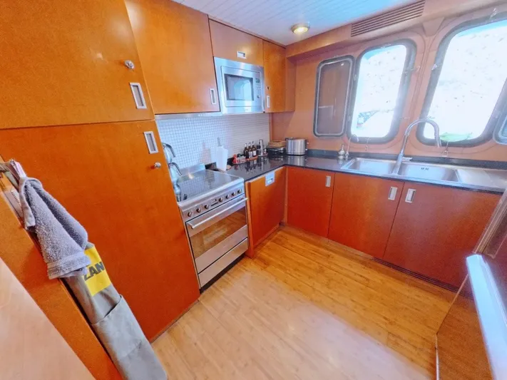 Risk Taker Yacht Photos Pics Kitchen interior of 2006 Tansu Custom Trawler with wooden cabinets and modern appliances.