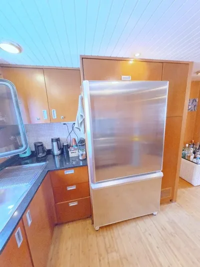 Risk Taker Yacht Photos Pics Kitchen area in 2006 Tansu Custom Trawler with stainless steel fridge and wooden cabinetry.