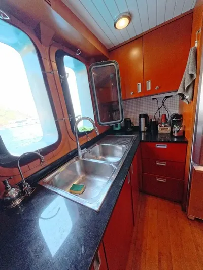 Risk Taker Yacht Photos Pics 2006 Tansu Custom Trawler kitchen with wooden cabinets, dual sink, and ocean view windows.