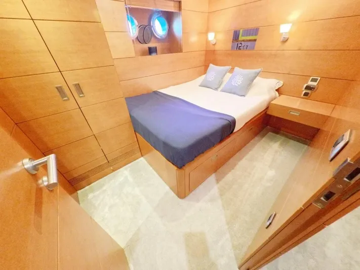 Risk Taker Yacht Photos Pics Luxurious cabin interior of 2006 Tansu Custom Trawler with wooden finish and cozy bedding.