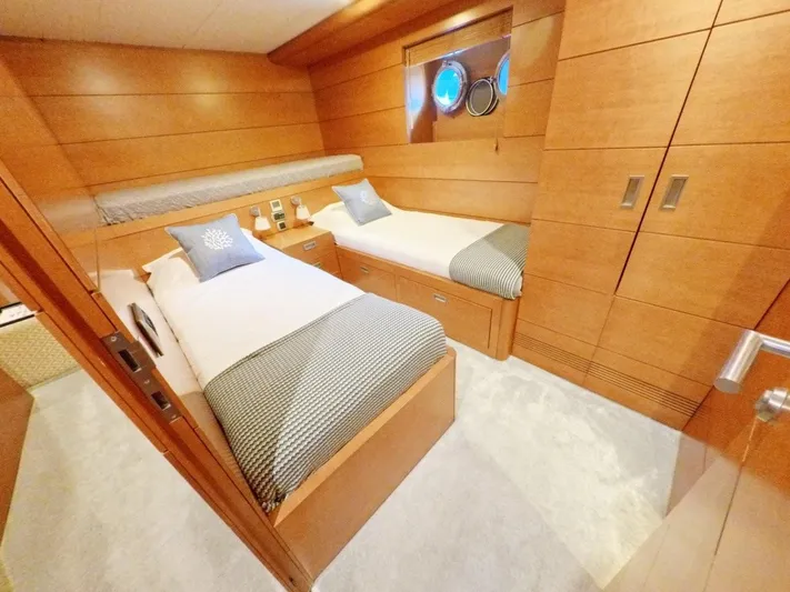 Risk Taker Yacht Photos Pics Twin cabin interior of 2006 Tansu Custom Trawler with wooden paneling and porthole windows.