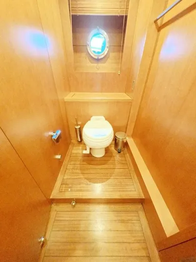 Risk Taker Yacht Photos Pics Wood-paneled bathroom on 2006 Tansu Custom Trawler with porthole window and modern fixtures.