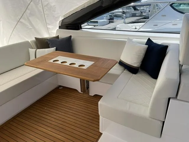  Yacht Photos Pics Luxurious seating area on 2020 Fairline 45/43 Targa yacht with wooden table and cushions.