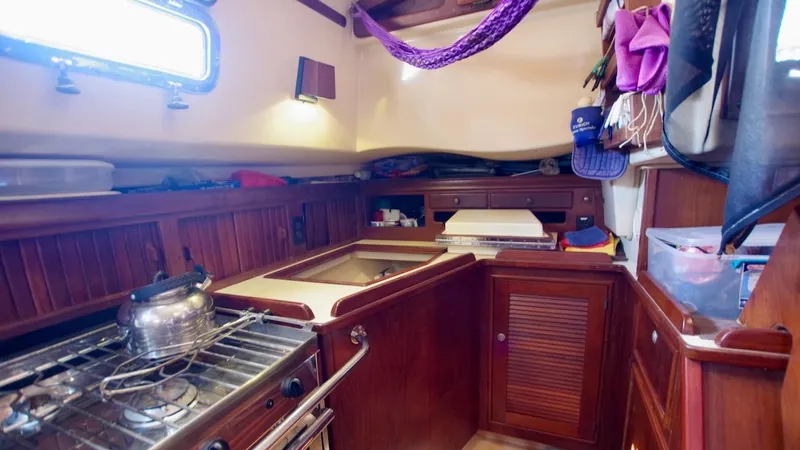 Azafran Yacht Photos Pics Cozy galley kitchen in 1994 Island Packet 40 sailboat with wooden cabinetry and stove.