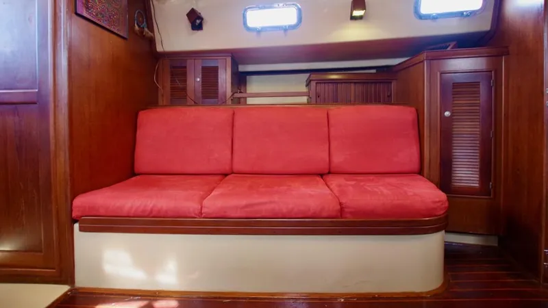 Azafran Yacht Photos Pics Red cushioned seating in 1994 Island Packet 40 sailboat interior.