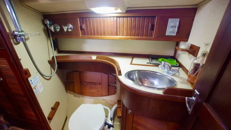 Azafran Yacht Photos Pics 1994 Island Packet 40 yacht bathroom with wooden cabinetry and stainless steel sink.