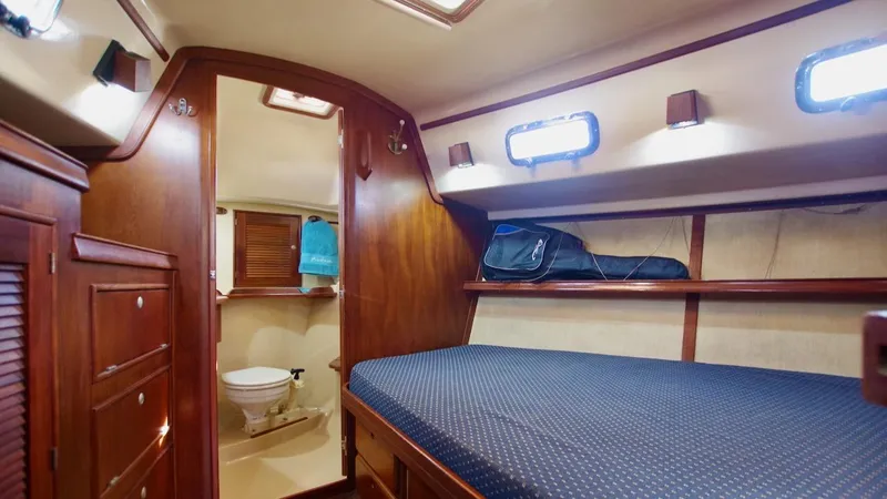 Azafran Yacht Photos Pics 1994 Island Packet 40 yacht interior with cozy cabin and bathroom, featuring wooden finishes and portholes.