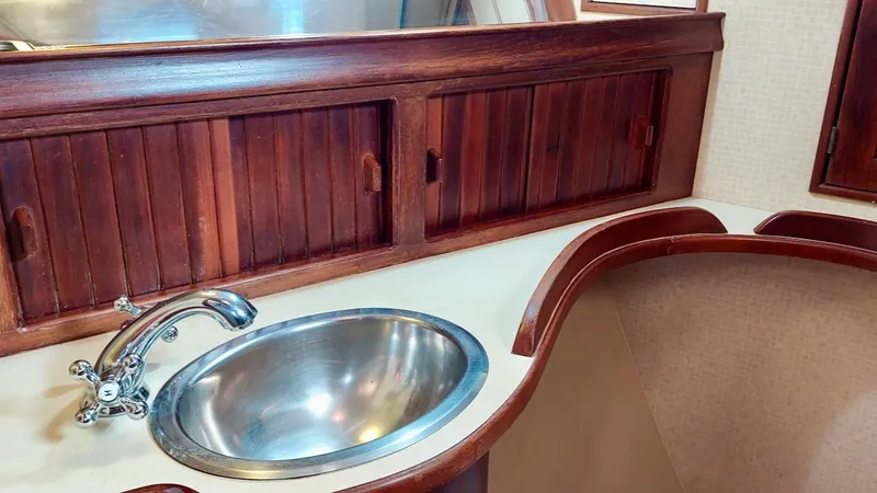 Azafran Yacht Photos Pics Island Packet 40 (1994) yacht interior with wooden cabinets and stainless steel sink.