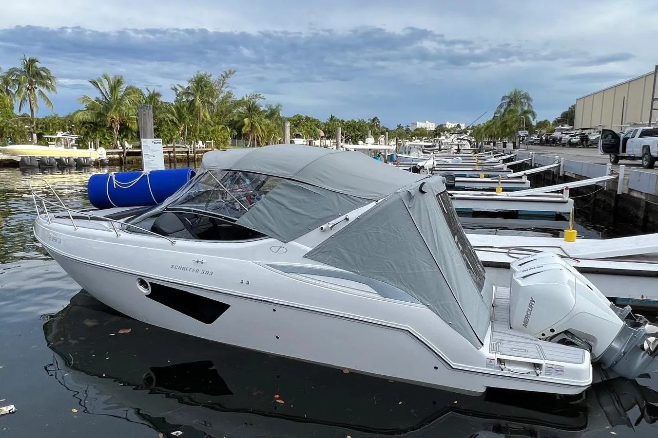Schaefer 303 boat docked, 2021 model, with canopy, in a marina setting.