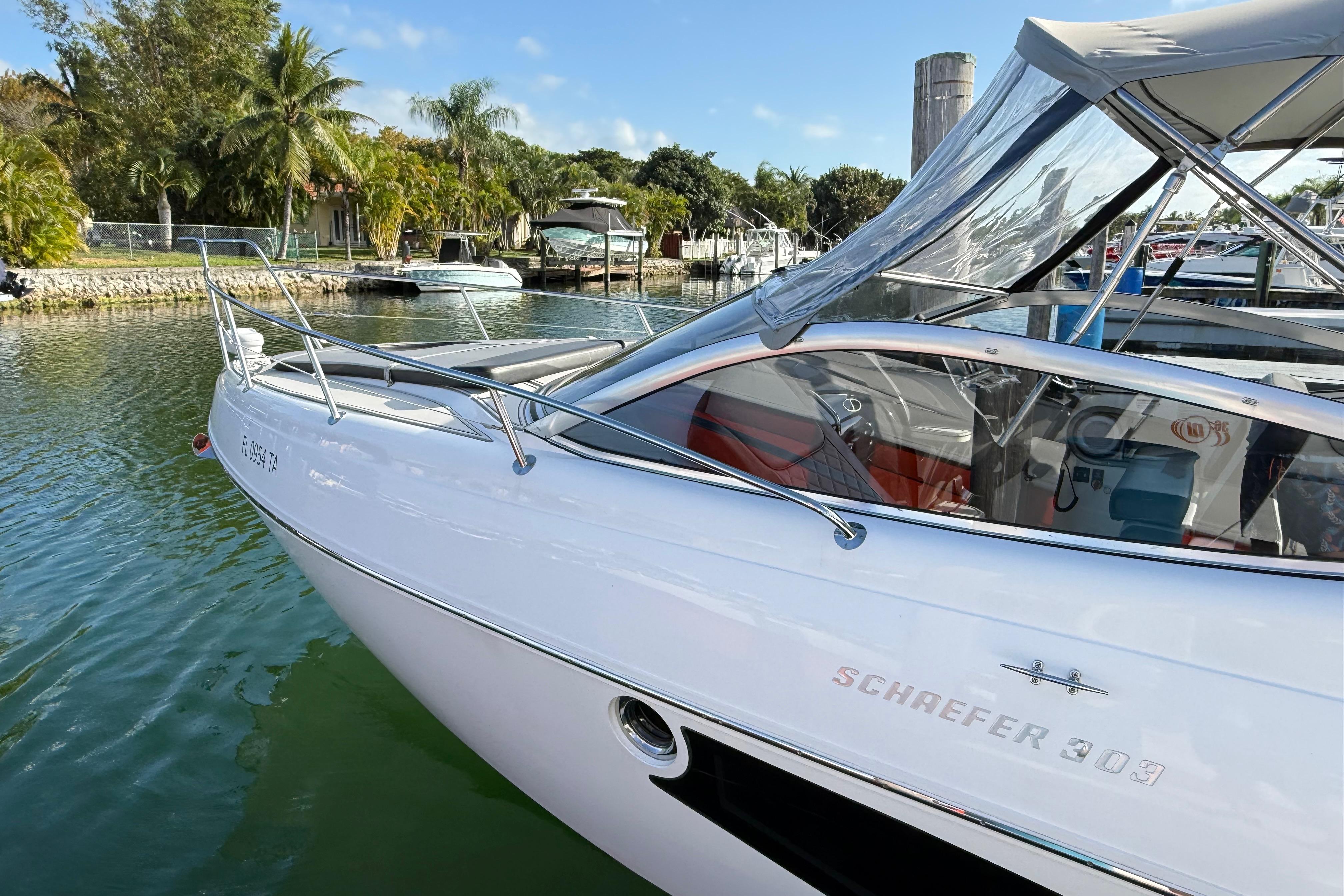 2021 Schaefer 303 boat docked in a scenic marina with palm trees.
