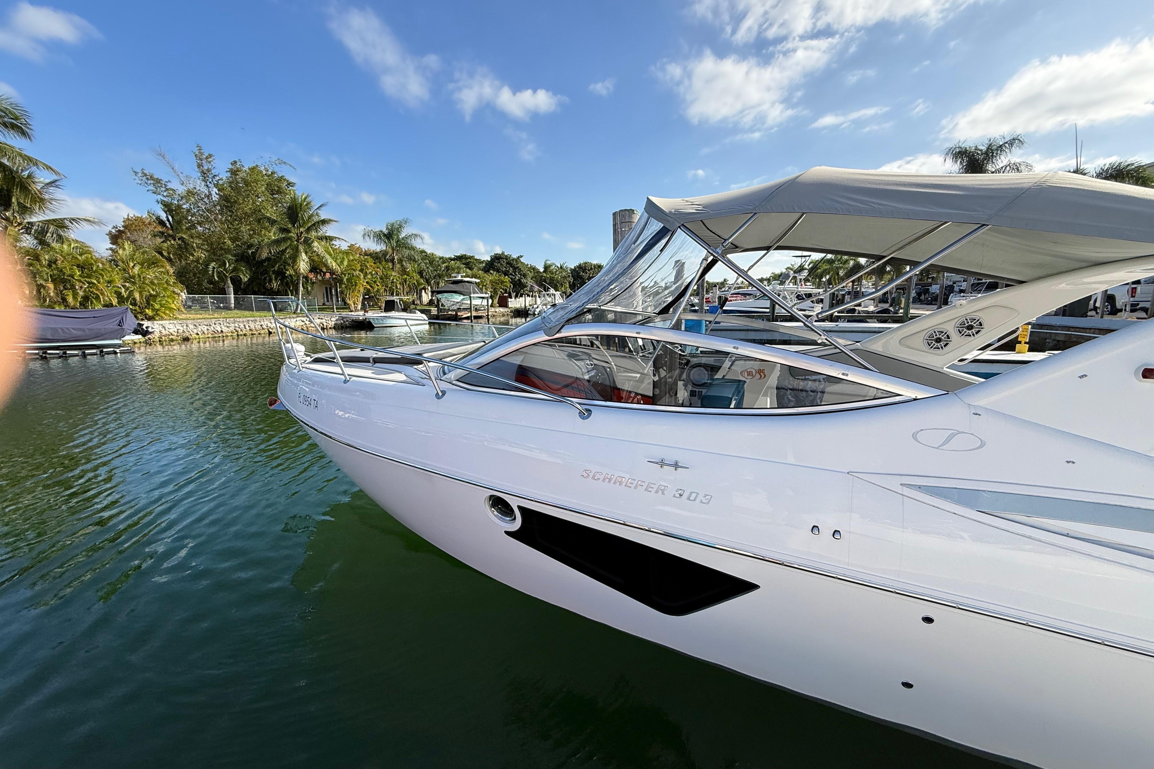2021 Schaefer 303 boat docked in a scenic marina with palm trees.