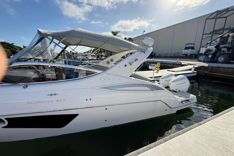  Yacht Photos Pics 2021 Schaefer 303 boat docked, featuring sleek design and Mercury outboard engines.
