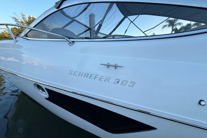  Yacht Photos Pics 2021 Schaefer 303 boat side view with sleek white design and logo.