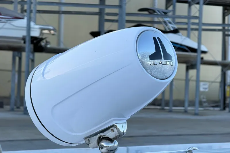  Yacht Photos Pics White JL Audio speaker on a 2021 Schaefer 303 boat, with docked boats in the background.