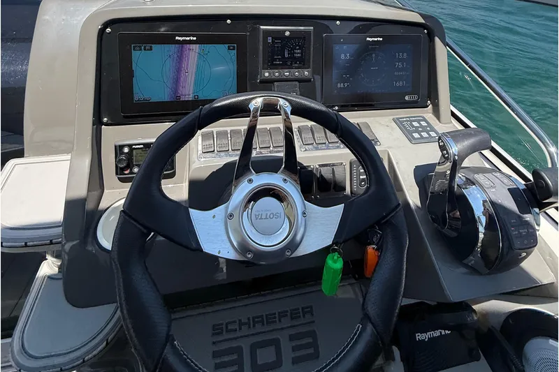  Yacht Photos Pics Steering console of 2021 Schaefer 303 boat with navigation displays and controls.