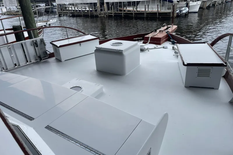 Georgia Yacht Photos Pics 1967 Huckins Offshore boat deck with storage boxes, docked at a marina.
