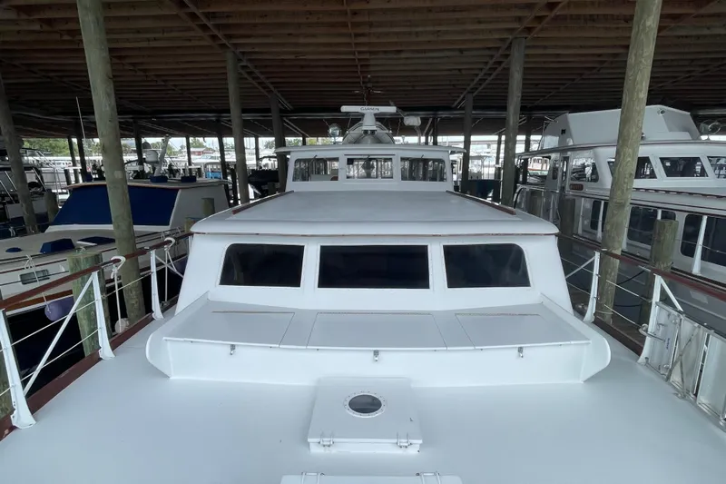 Georgia Yacht Photos Pics 1967 Huckins Offshore yacht docked in a covered marina, showcasing classic design.
