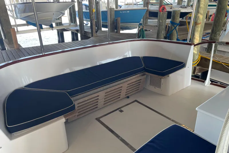 Georgia Yacht Photos Pics 1967 Huckins Offshore boat interior with blue cushioned seating at a dock.