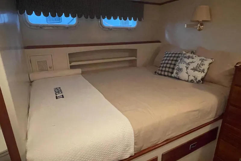 Georgia Yacht Photos Pics Cozy bedroom interior of a 1967 Huckins Offshore yacht with elegant bedding and decor.