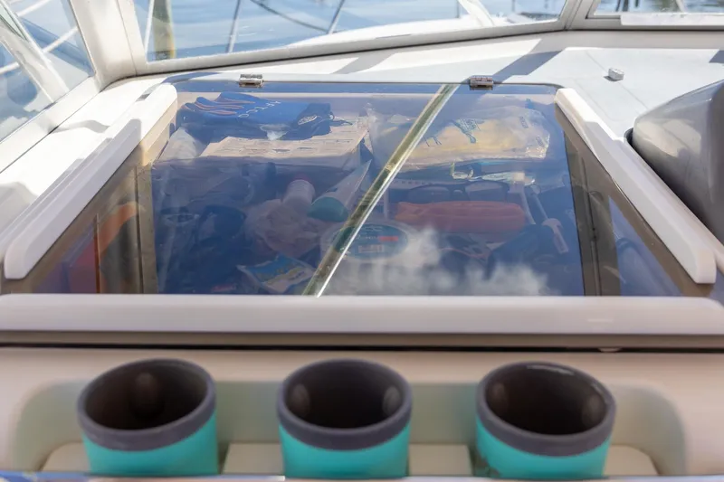  Yacht Photos Pics 1997 Tiara Yachts 3500 Express cockpit with storage compartment and cup holders.