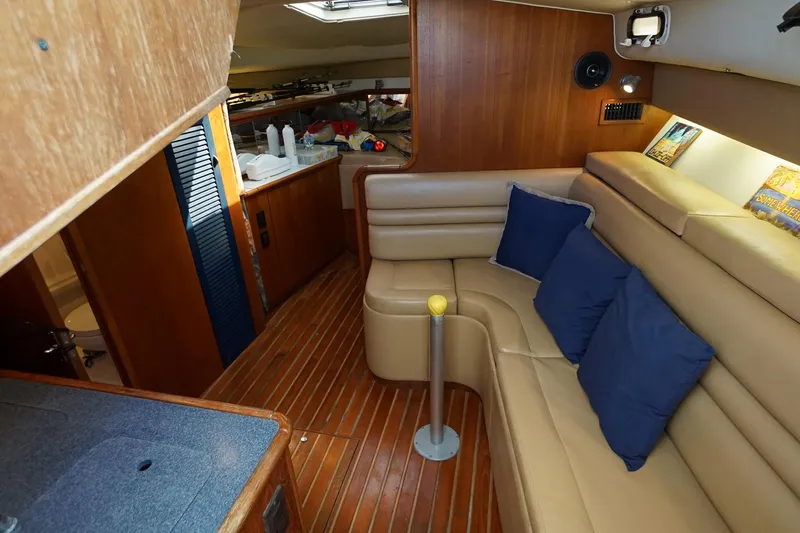  Yacht Photos Pics 1997 Tiara Yachts 3500 Express interior with beige seating, blue cushions, and wooden accents.
