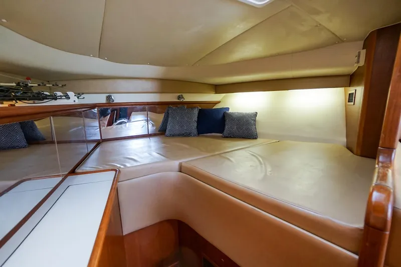  Yacht Photos Pics 1997 Tiara Yachts 3500 Express cabin interior with cushioned seating and decorative pillows.