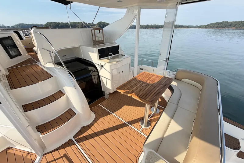 This Bar Yacht Photos Pics Luxurious 2004 Meridian 459 Motoryacht interior with elegant seating and wooden table on calm waters.