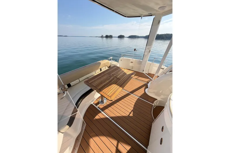 This Bar Yacht Photos Pics 2004 Meridian 459 Motoryacht deck with wooden flooring and scenic water view.