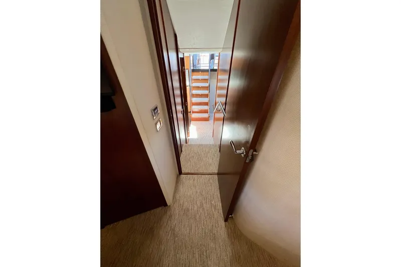  Yacht Photos Pics Interior hallway of 2010 Princess V78 yacht with wooden doors and carpeted floor.
