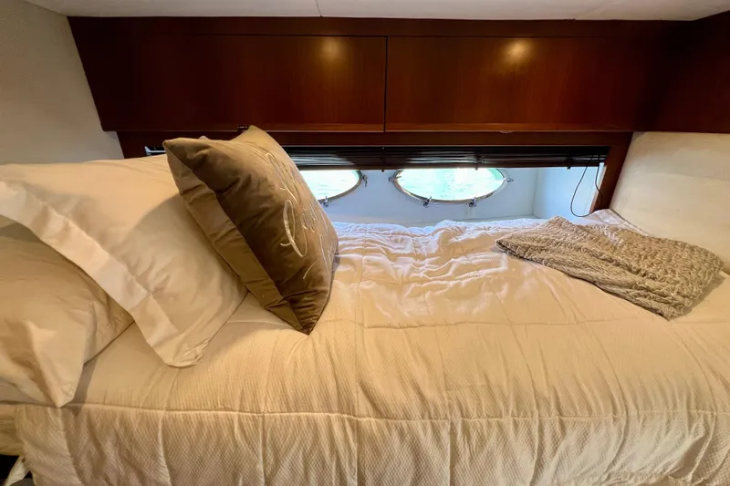  Yacht Photos Pics Cozy bedroom in 2010 Princess V78 yacht with porthole view and plush bedding.