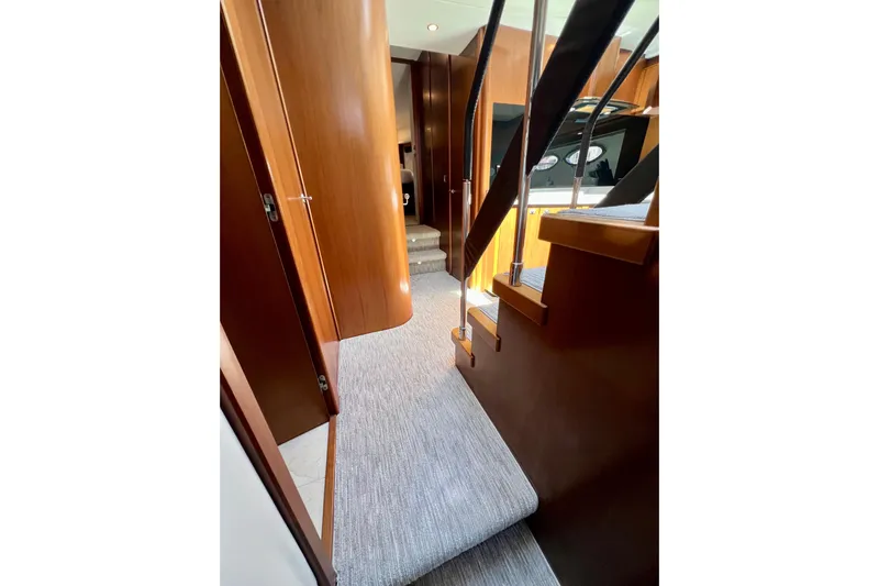  Yacht Photos Pics Interior view of 2010 Princess V78 yacht with wooden finishes and carpeted stairs.