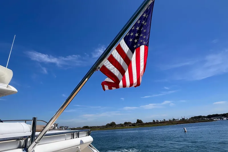  Yacht Photos Pics American flag on a 2010 Princess V78 yacht against a clear blue sky.