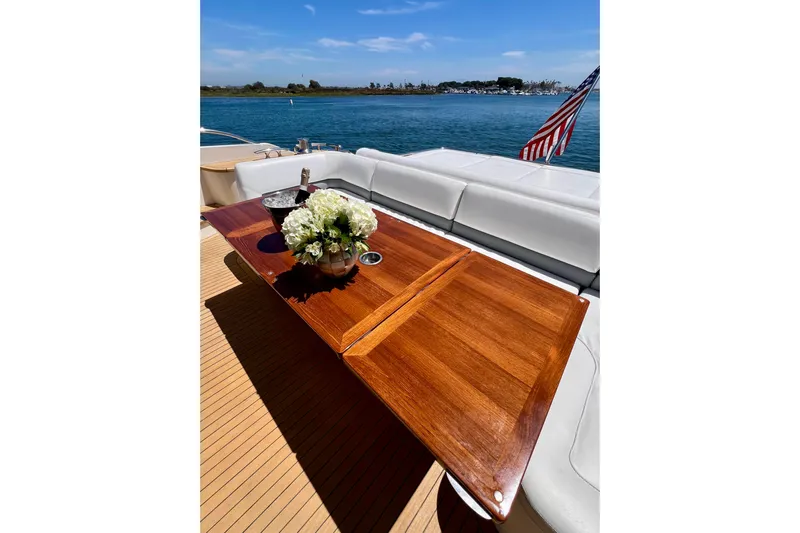  Yacht Photos Pics Luxurious 2010 Princess V78 yacht deck with wooden table, flowers, and ocean view.