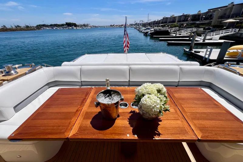  Yacht Photos Pics Luxurious 2010 Princess V78 yacht deck with wooden table, flowers, and champagne, overlooking marina.