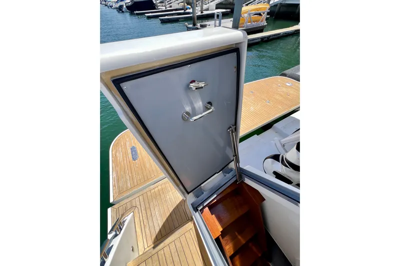  Yacht Photos Pics Open hatch on 2010 Princess V78 yacht, revealing wooden stairs and marina view.